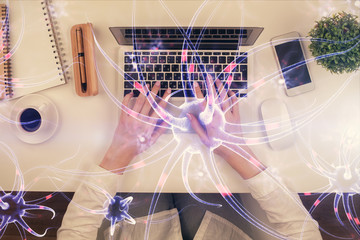 Double exposure of woman hands working on computer and neuron hologram drawing. Top View. Science concept.