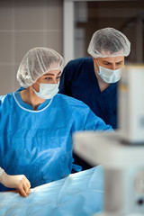 Photographs of doctors in protective masks and lab coats work intensively in intensive care....