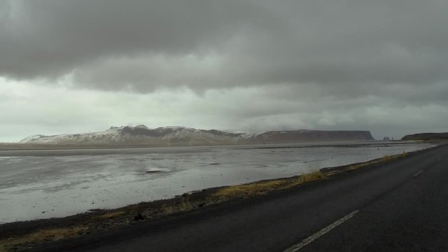 Dolly shot camera moves forward along a beautiful lake with snowy mountain in background in Iceland