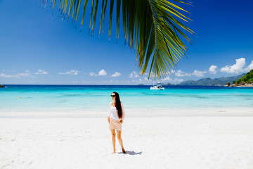 Fototapeta na wymiar woman relax on luxury resort beach with palm tree and yacht background