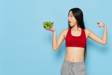 young woman holding green salad