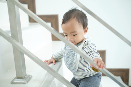Asian 10 months old toddler baby girl child climbing up stairs at home alone, Movement, Balance & Coordination, Stair climbing developmental milestone concept