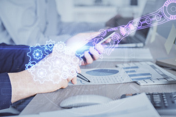 Fototapeta premium Double exposure of man's hand holding and using a digital device and data theme hologram drawing. Technology concept.