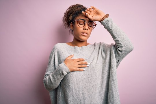 Young beautiful african american girl wearing sweater and glasses over pink background Touching forehead for illness and fever, flu and cold, virus sick