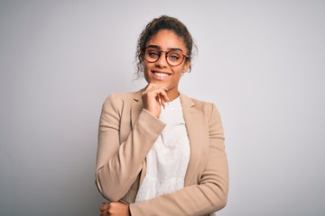 Beautiful african american businesswoman wearing jacket and glasses over white background looking...