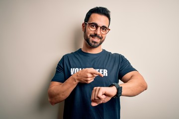 Handsome man with beard wearing t-shirt with volunteer message over white background In hurry...