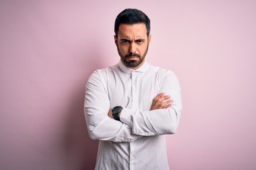 Obraz premium Young handsome man with beard wearing casual shirt standing over pink background skeptic and nervous, disapproving expression on face with crossed arms. Negative person.