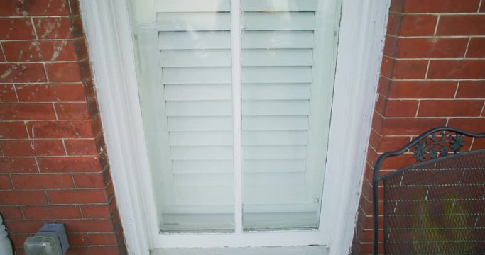 Gimbal shot of the outside of a window in a brick house
