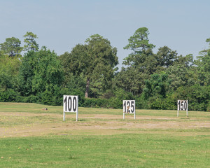 Fototapeta na wymiar Golf course driving range yardage signs for 100, 125, 150 feet target on natural grass field