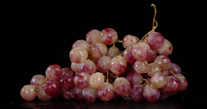 A bunch of grapes falling water drops.