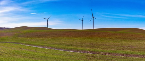 Fototapeta na wymiar Wind power turbines at ease on a plowed field 