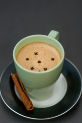 cup of coffee with a winged plant on a ceramic table