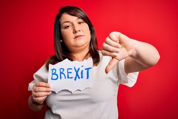 Beautiful plus size woman holding brexit banner for political referendum in europe with angry face, negative sign showing dislike with thumbs down, rejection concept