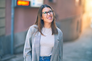 Young beautiful woman smiling happy and confident. Standing with smile on face at the town street