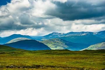 Obraz premium Light dapples hills in Scottish Highlands on cloudy day
