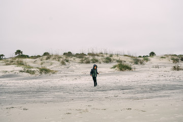 Fototapeta na wymiar child alone on the beach on a cloudy day