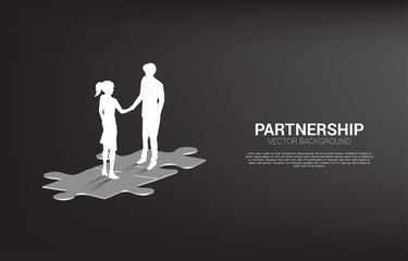 Silhouette of businessman handshake on jigsaw. Concept of team work partnership and cooperation.