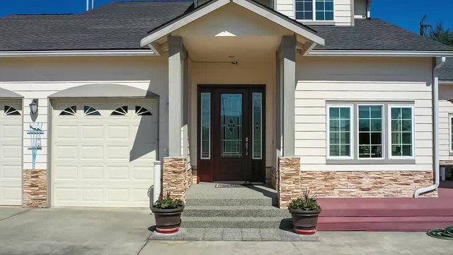 Aerial footage of a modern suburban home, zooming in to the front door