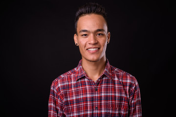 Face of happy young Indian hipster man smiling