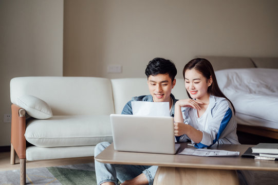 Young Asian couple at home using computer