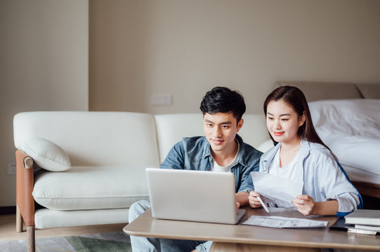 Young Asian couple at home using computer