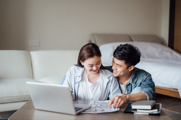 Young Asian couple at home using computer