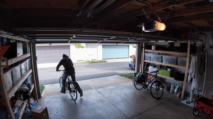 Person stealing bicycle from garage, surveillance camera view
