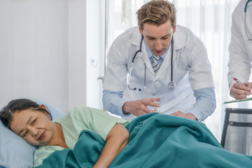 Fototapeta premium healthcare background of caucasian medical doctor make disease treatment for senior asian female patient lying on bed by antibiotic injection in hospital