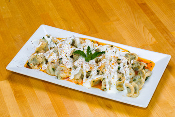 Turkish Manti with red pepper, tomato sauce, yogurt and mint (dumplings) 