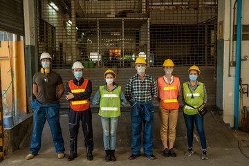 Team engineers and technician wearing protective mask to Protect Against Covid-19 standing at factory.