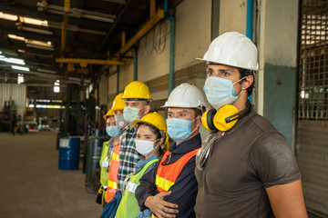 Team engineers and technician wearing protective mask to Protect Against Covid-19 standing at factory.