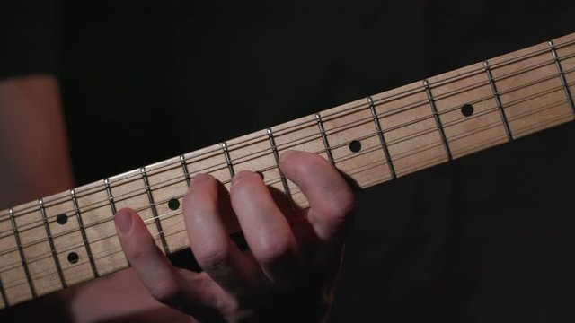 Male guitarist practicing scales on electric guitar, close up slow motion 4K