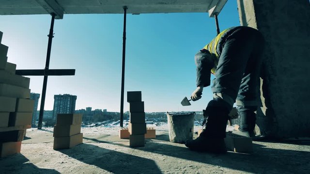 Construction worker at a construction site. Masonry is being held by a construction worker at the building lot