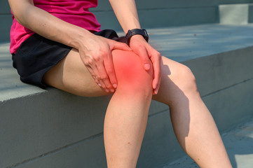Close up of woman runner suffering from Iliotibial Band Syndrome (ITB). It cause from overuse...