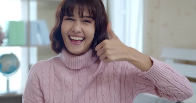 Happy young asian woman smile and thump up feels good
