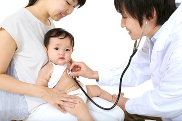 お母さんに抱かれれ診察を受ける赤ちゃん