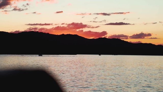 sunset over dark mountains on lake