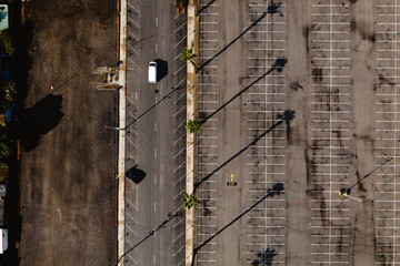 Aerial drone shot of an empty car park. Long shadows are cast over the car park as the sunsets. 
