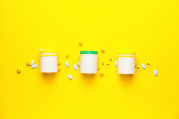 Bottles with pills on color background