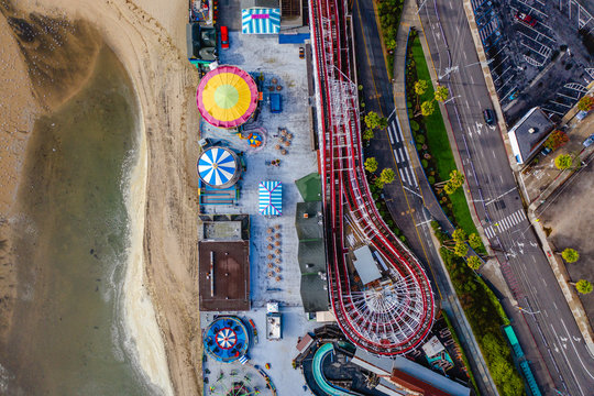 Top-down drone shot of an amusement park on the beach. 