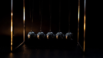 Newtons cradle metal ball moving on black background