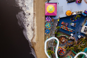 Top-down drone shot of an amusement park on the beach. 