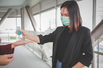 Two woman Asian people use alcohol gel disinfecting skin with hand sanitizer prevent infection, outbreak of Covid-19.