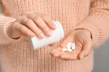 Woman with bottle of pills, closeup