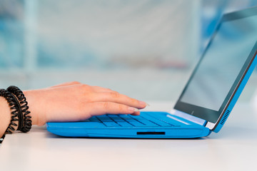 The girl at the table works on a laptop