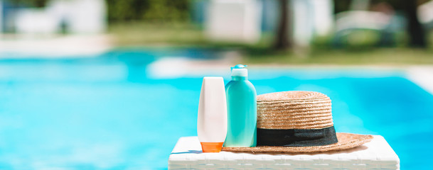 Suncream bottles, goggles, starfish on the edge of the pool