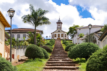 Stairway to a colonial chapel and buildings on top of a hill in historical town Serro on a sunny day, Minas Gerais, Brazil