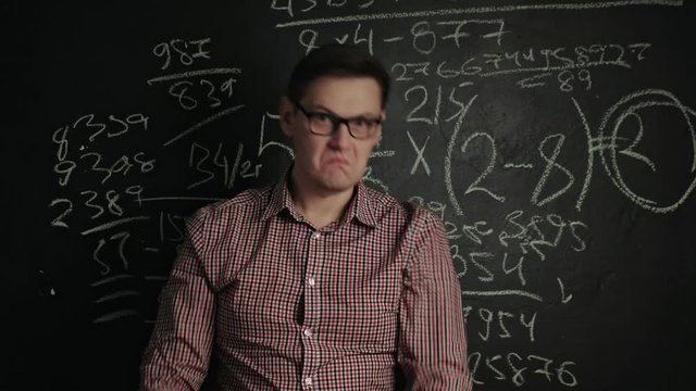 man writes math formula on blackboard