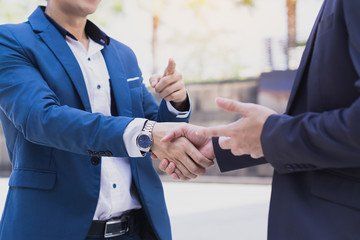 Two business man making handshake in the city. Business etiquette, congratulation, merger and acquisition concepts.