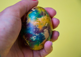 Human hand holding single colorful egg, body part, fingers, one multicolored egg, Easter tradition, celebration concept